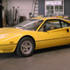 Yellow Ferrari 308 GTBi in a garage.